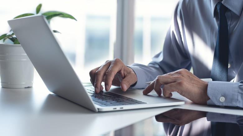 person using gestures on laptop