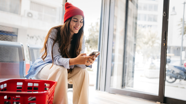 woman using iphone at laundromat