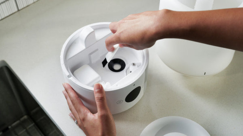 Hand brushing the base of humidifier