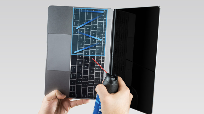 Person cleaning MacBoook keyboard