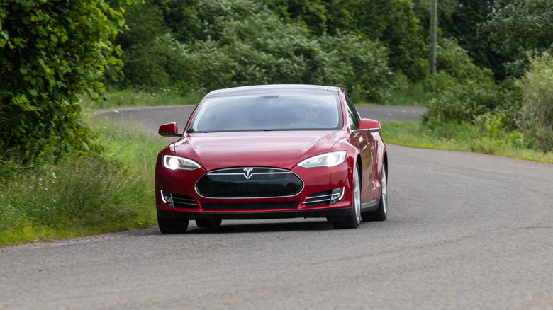 Red Tesla Model S driving on the road