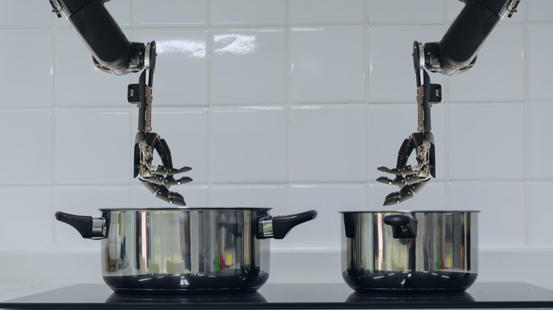 two robot arms over pots