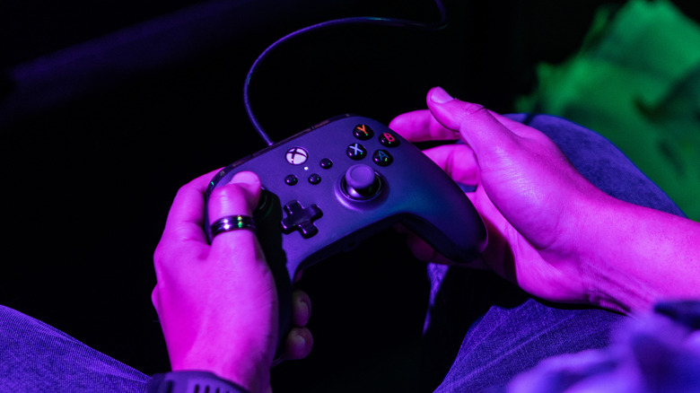 person holding black xbox one controller