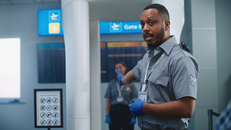 TSA agent telling a person to go through security