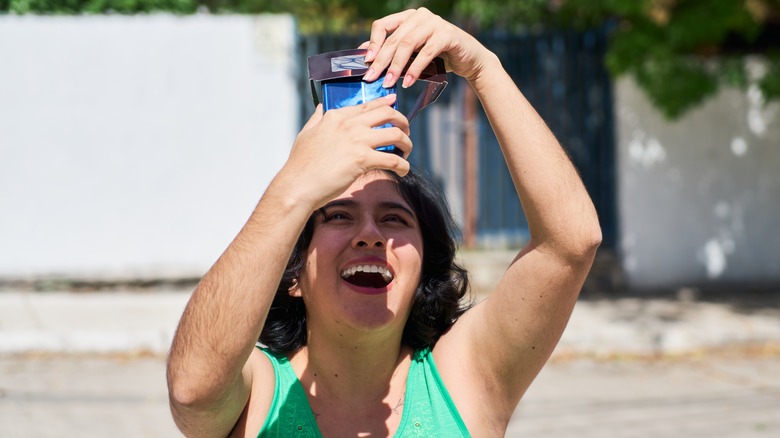 woman photographing solar eclipse smartphone