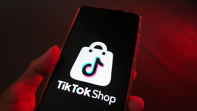 TikTok Shop logo on phone in red room