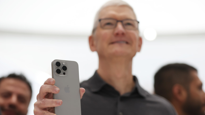 Cook holding up an iPhone