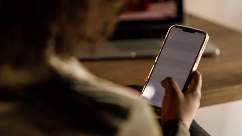 woman using iphone in dim lighting