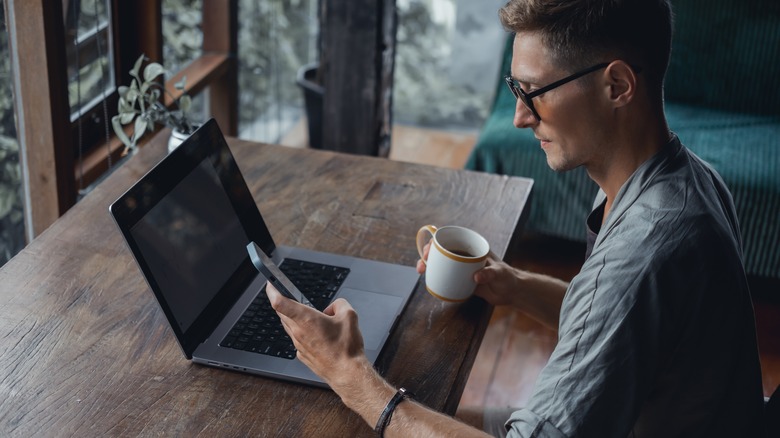 man checking iphone while working