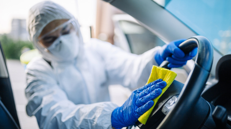 Professional car cleaner wiping steering wheel