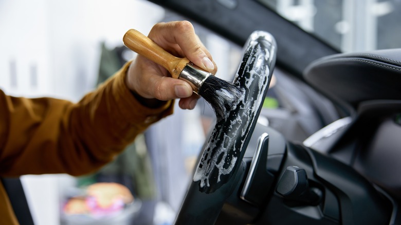 Driver brushing steering wheel clean