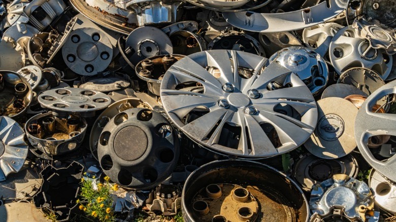 A pile of old automotive hubcaps, center caps, and wheel covers