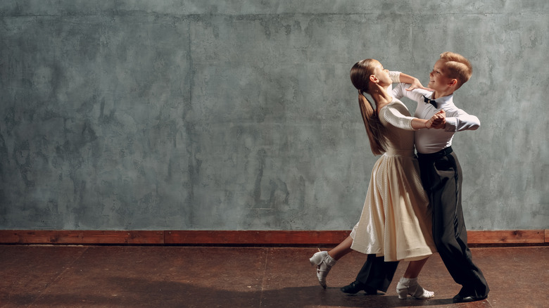 young boy and girl waltzing in a ballroom