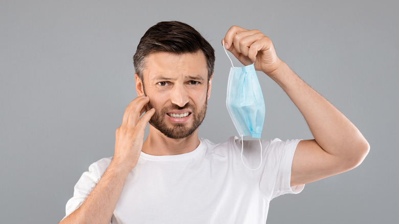 man holding blue face mask