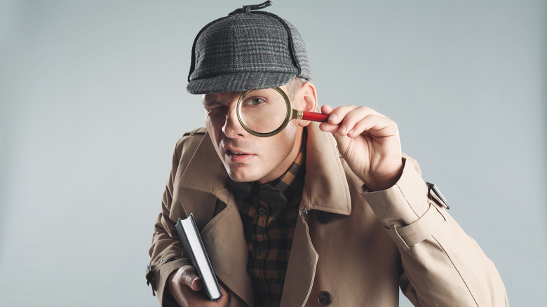 detective holding magnifying glass