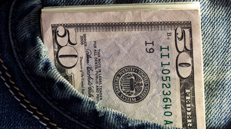 fifty dollar bill sticking out of jean pocket