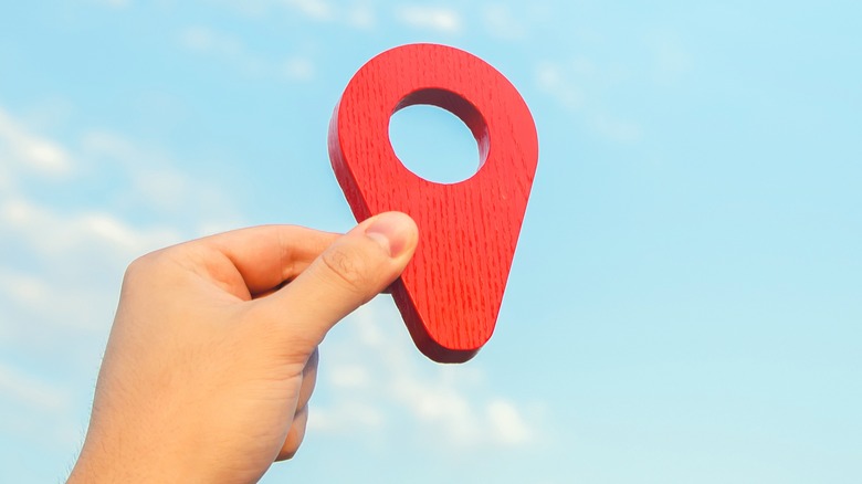 person holding a red pin