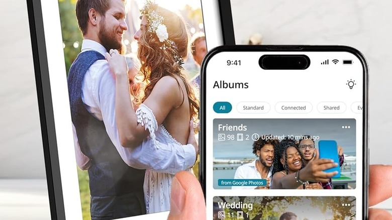 A person uses the Nixplay app to add photos to a digital picture frame that already holds a picture of a couple dancing.