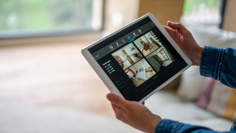 Person holding a tablet with security camera app display