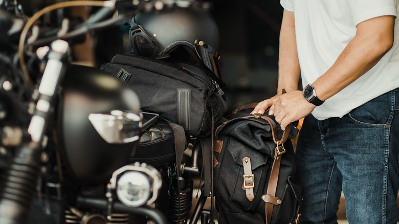 Person loading motorcycle with equipment