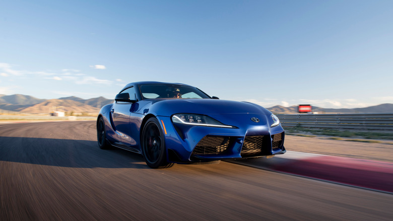 Toyota Supra driving around racetrack, front-right three-quarter view