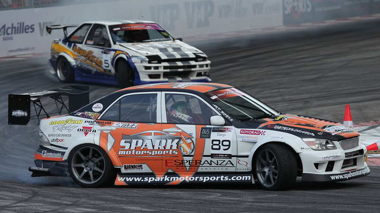 Toyota Altezza at drift event with AE86 in background