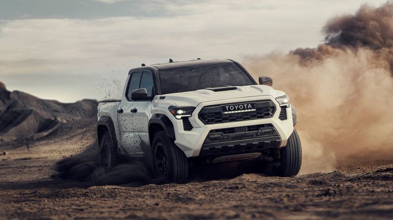 White Toyota Tacoma drifting in dirt