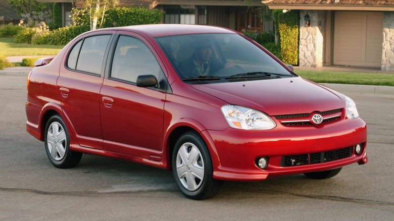 A red Toyota Echo with a driver within