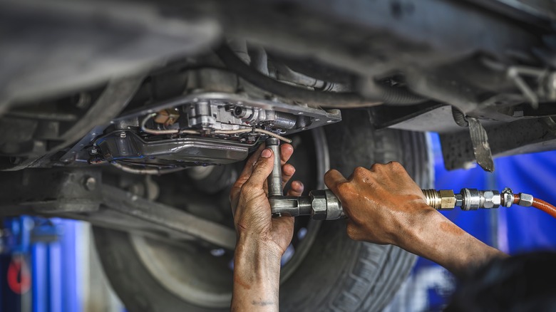 Two hands working on car engine