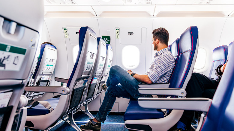 Man looking out the window on an airplane