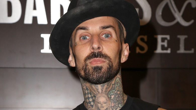 Travis Barker posing wearing hat