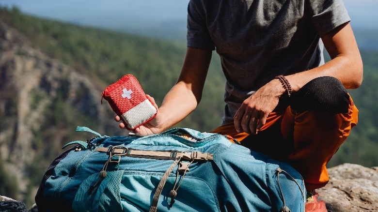 Person with first aid kit in wilderness