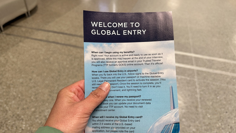 person holding a Global Entry pamphlet