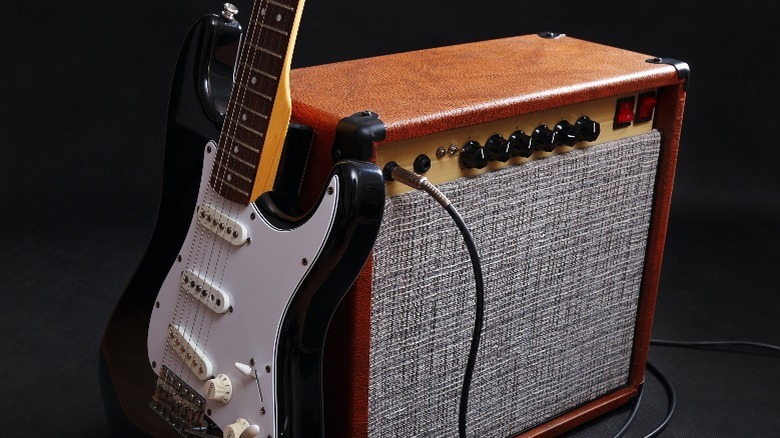 Fender Stratocaster guitar next to guitar amplifier