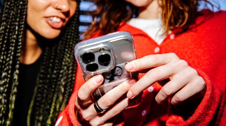 Two people looking happily at a phone