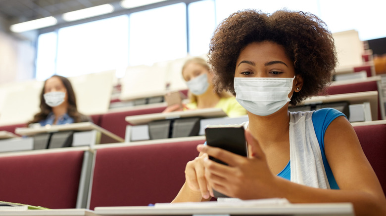 woman using phone with mask