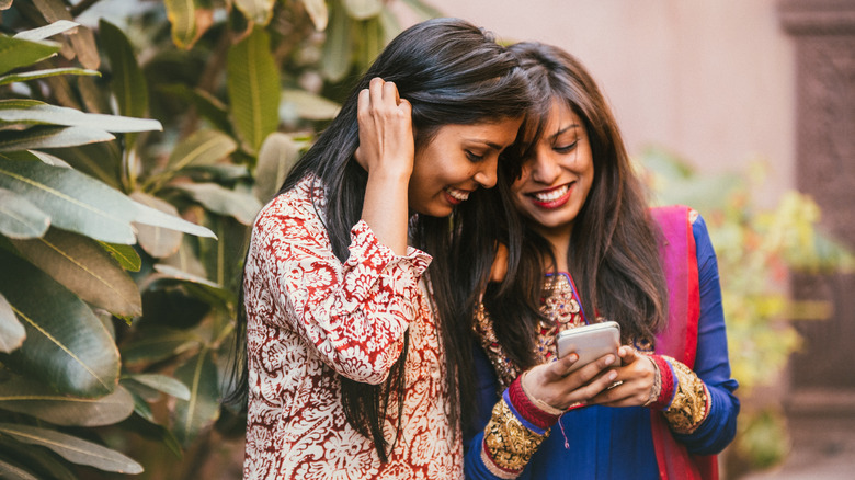 two women using one phone