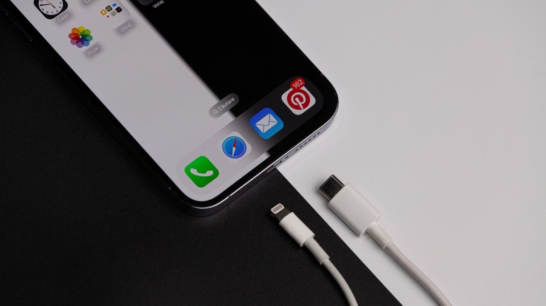 iPhone with a lightning and USB-C cable next to it