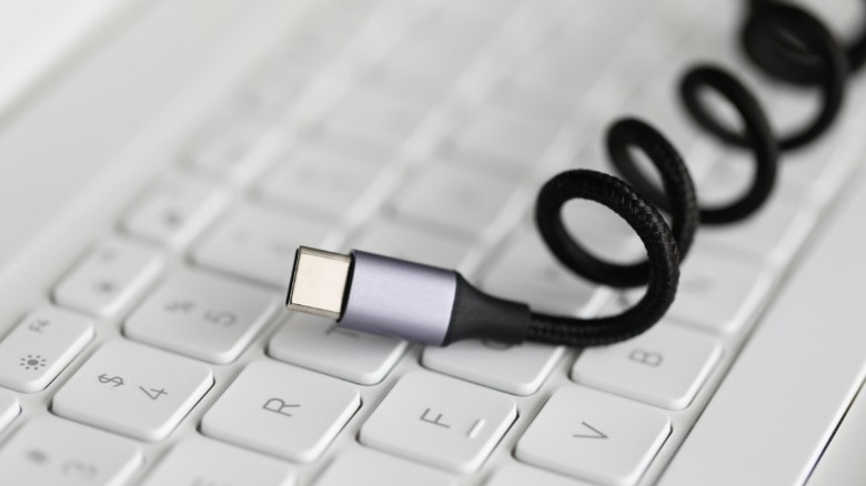 Coiled up USB-C cable on a laptop's keyboard