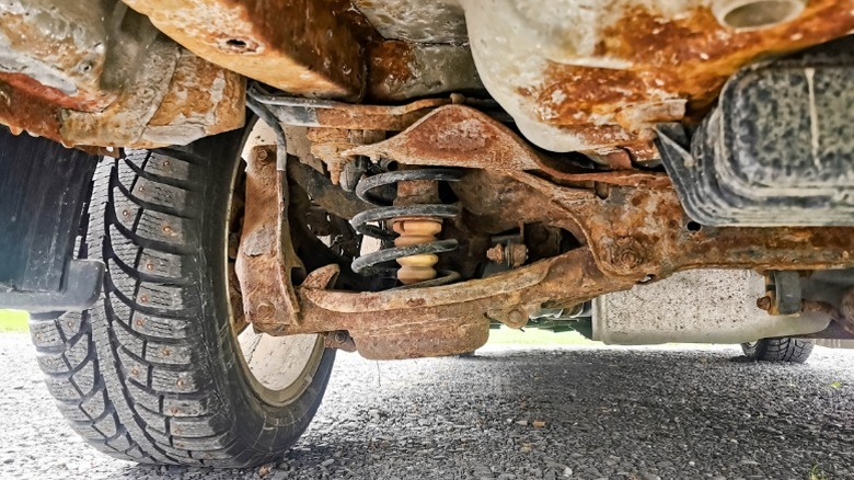 The bottom of a car with extensive rusting