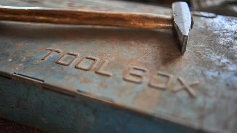 a vintage toolbox with a hammer on top