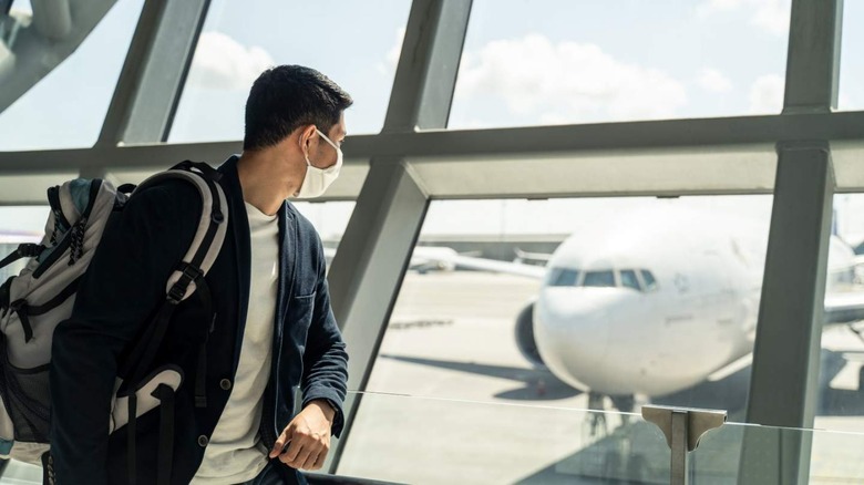 Man looking at plane in airport