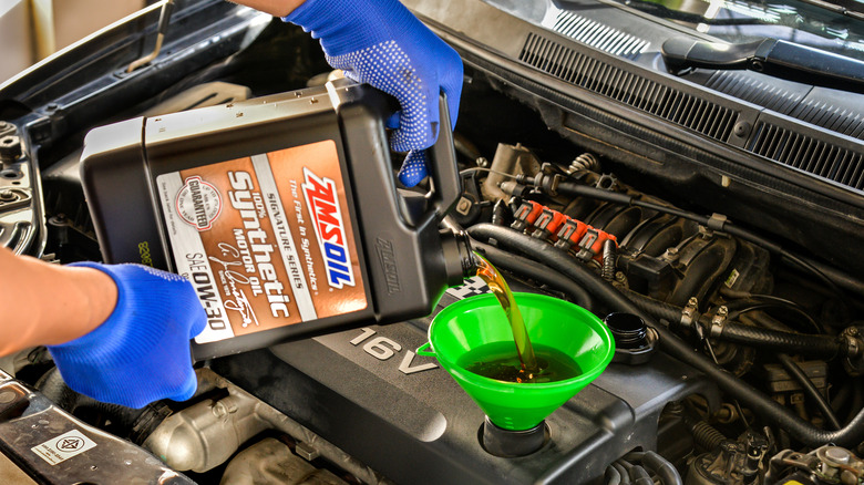 Pouring Amsoil motor oil