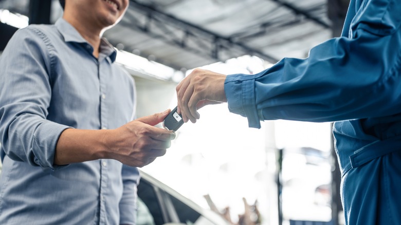 mechanic handing keys to customer