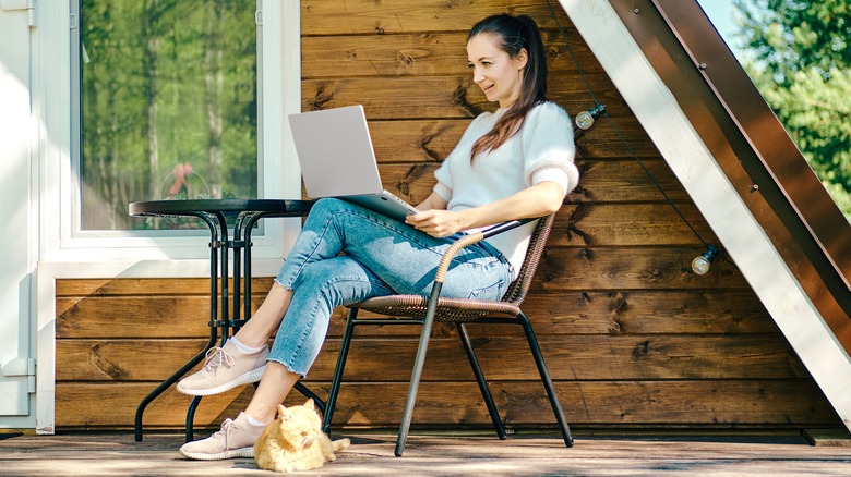 woman typing novel in cabin