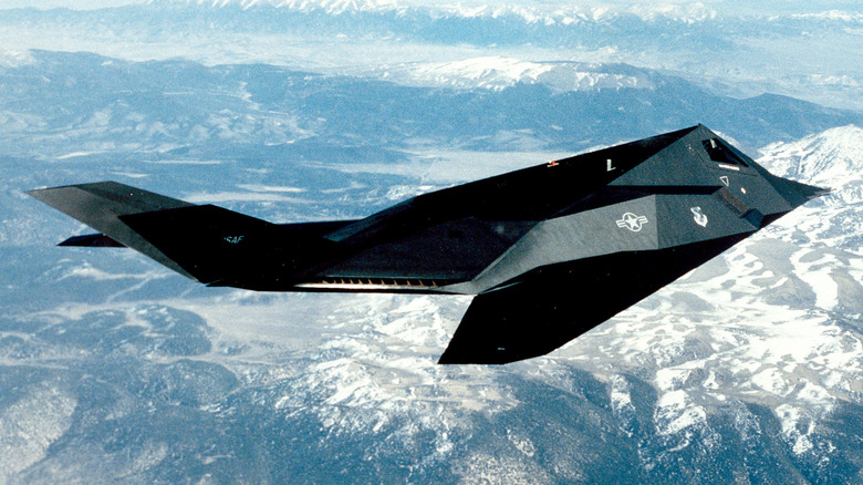 A profile view of an F-117 Nighthawk midair