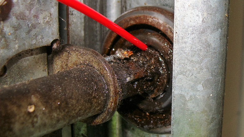 Superzilla being applied to rust on a garage door wheel