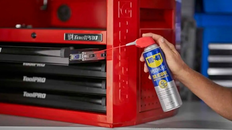 Person spraying toolbox with WD-40