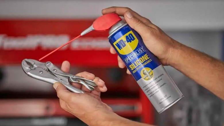 Person spraying wrench with WD-40