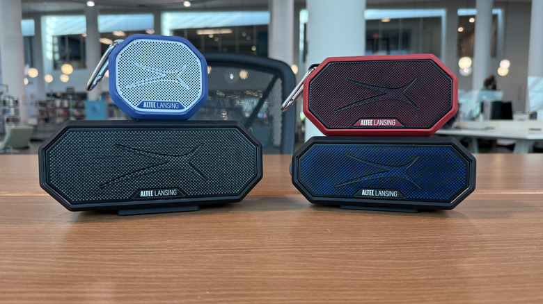 Four speakers sitting on a table.